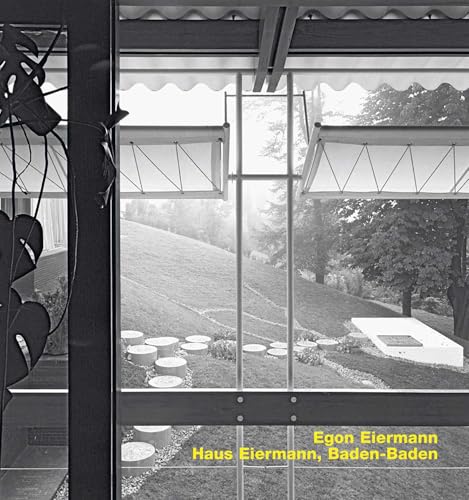 Black and white view through a modern window showing a garden and sloped lawn.