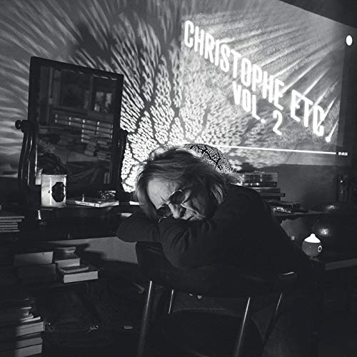 Black and white photo of a man with album artwork projection.