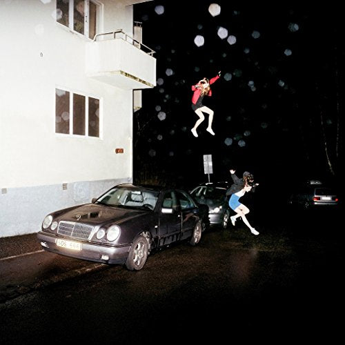 CD cover: people levitating near a building and parked cars at night.