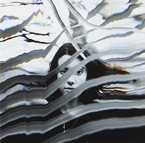 Black and white portrait of a person obscured by distorted, wavy lines.