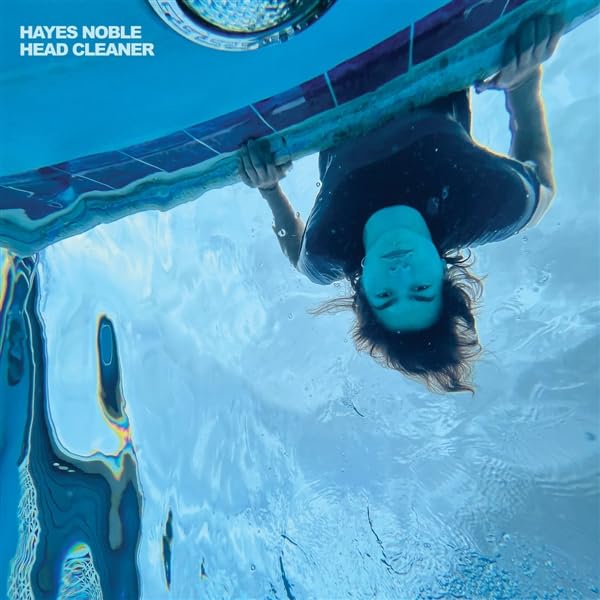 Underwater portrait of a person with distorted reflections in blue water.