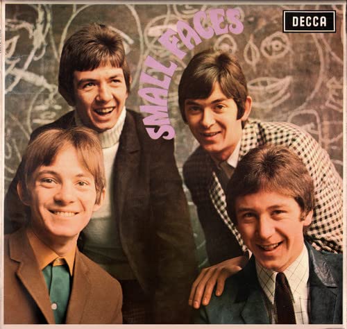 The four members of the band Small Faces posing in front of a chalkboard background.