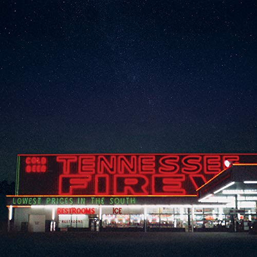 Nighttime view of a building with a glowing “Tennessee Fire” neon sign.