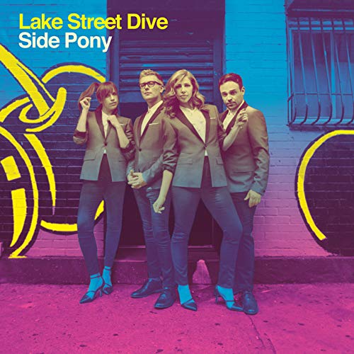 Lake Street Dive band members in suits pose in front of graffiti.