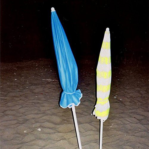 Two beach umbrellas, one blue and one yellow-striped, on sand.