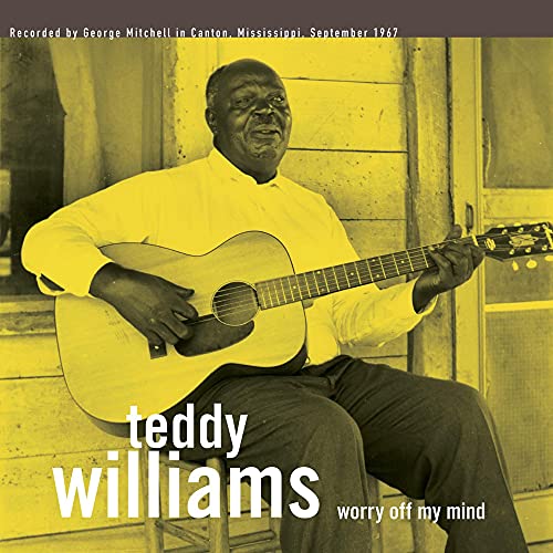 Teddy Williams seated, playing an acoustic guitar, album cover art.