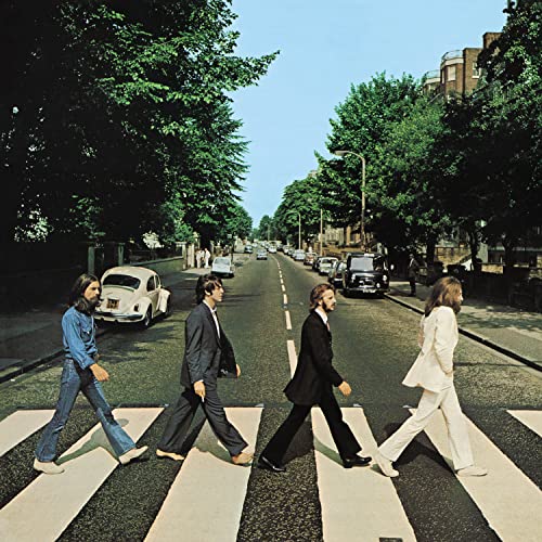 The Beatles walking across a zebra crossing on Abbey Road.