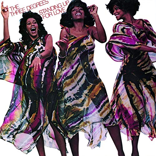 Three women of The Three Degrees in colorful, flowing dresses.