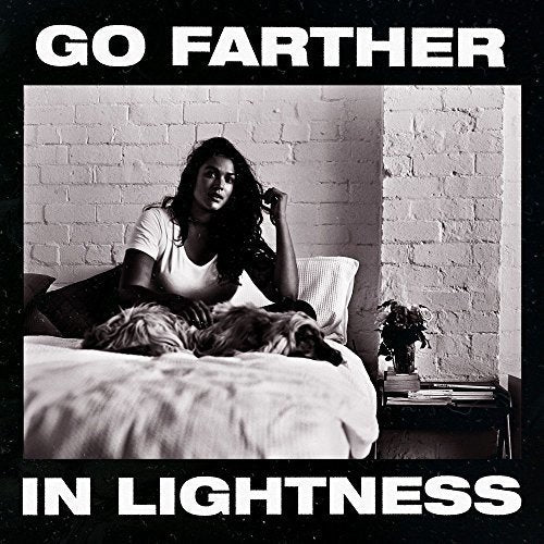 Album cover: woman with dog on a bed, brick wall background.