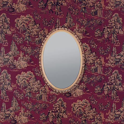 Oval mirror framed in gold, set against a detailed red toile pattern.