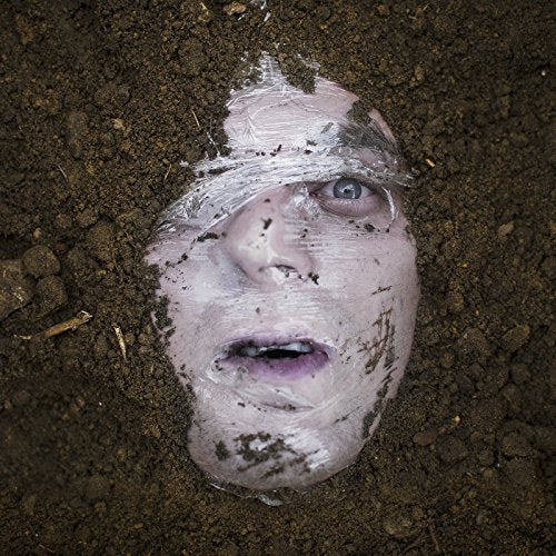 Face covered in dirt and white material, eyes open, looking up.