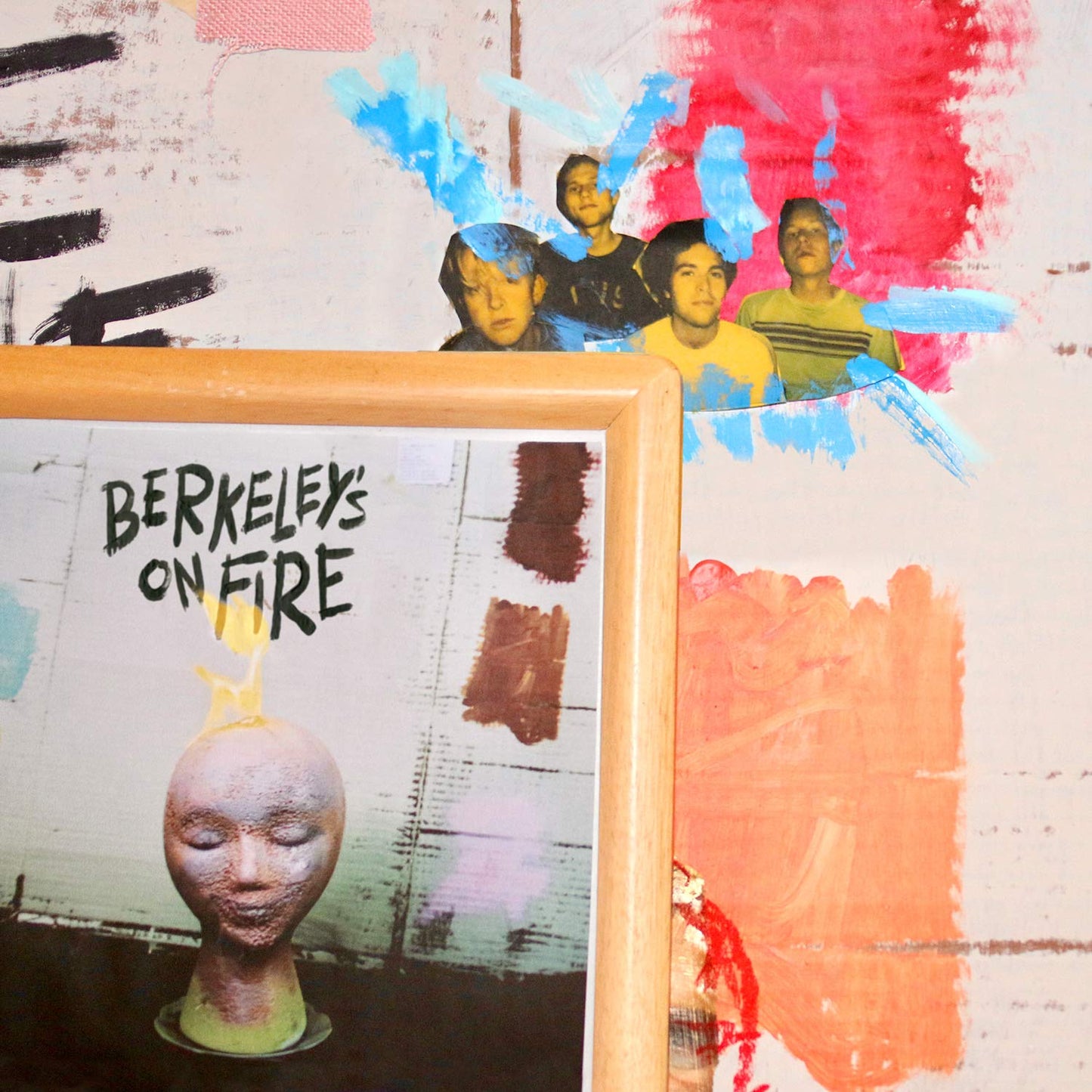 CD album cover with painted figures and a sculpted head.