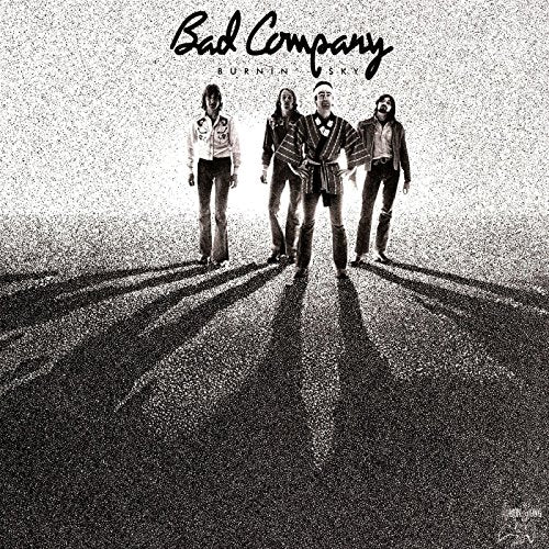 Black and white album cover featuring four men standing in sunlight.