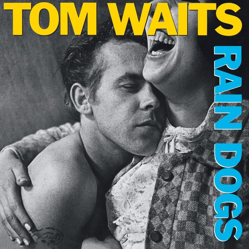 Tom Waits’ “Rain Dogs” album cover, black and white portrait with blue text.