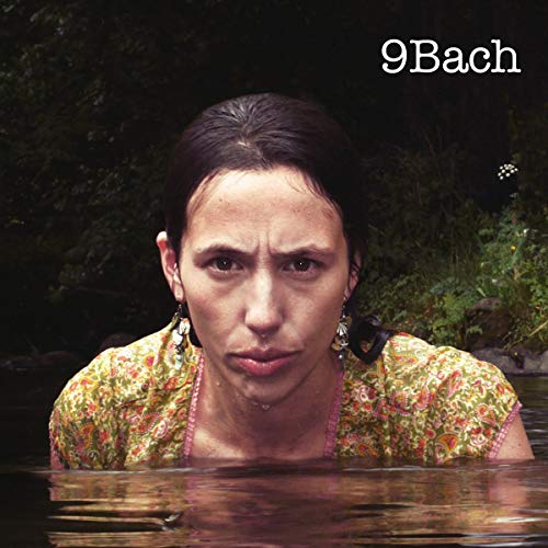CD cover: woman partially submerged in water, floral top, dark background.