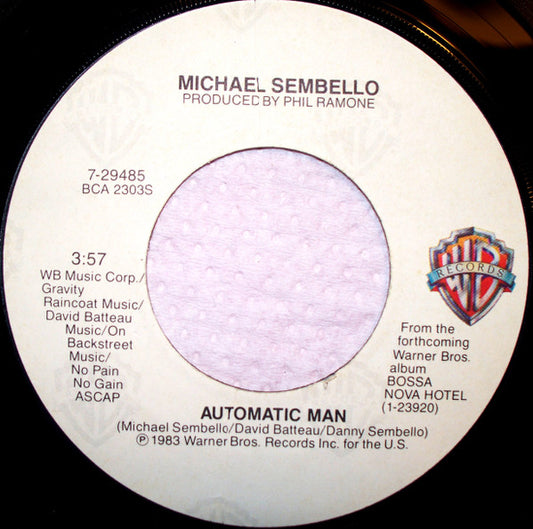 Close-up of a white vinyl record label with text and a Warner Bros. logo.