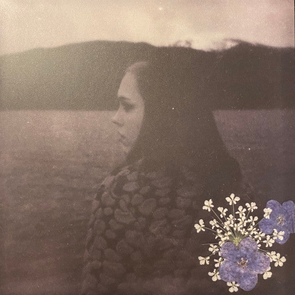 Sepia-toned album cover with a woman’s face and pressed flowers.