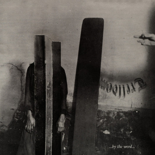 A person with a tall dark slab obscuring their face stands next to another slab.