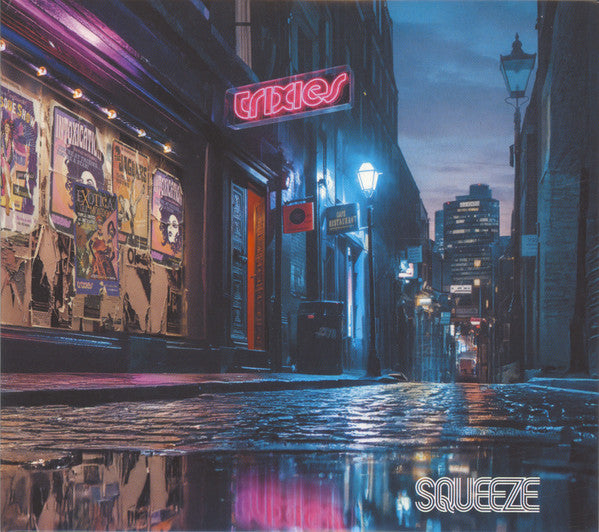 Wet city street at night with neon signs and building reflections.