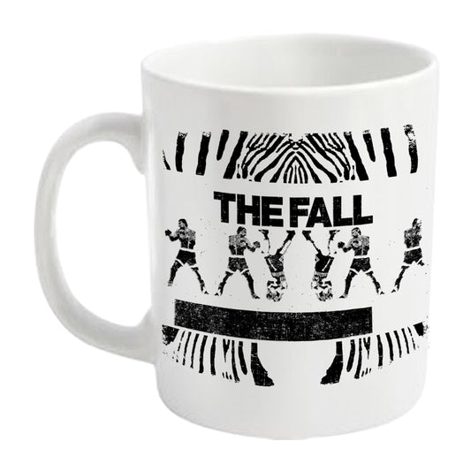 White mug with black graphic of figures and abstract lines, "THE FALL" text.