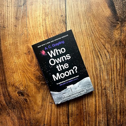 Book cover for Who Owns the Moon? by A. C. Grayling on wooden surface.
