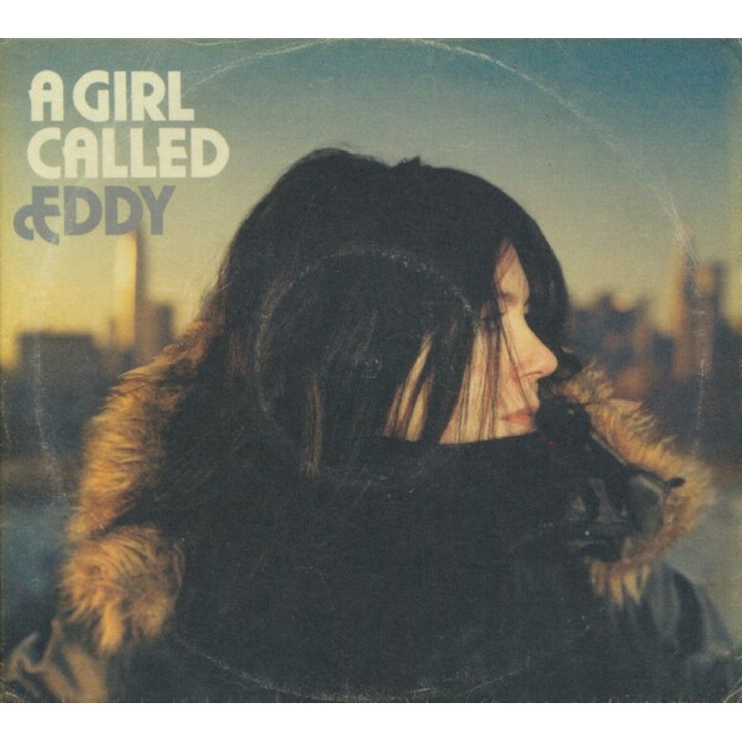 Album cover: woman in fur coat, city skyline in background.