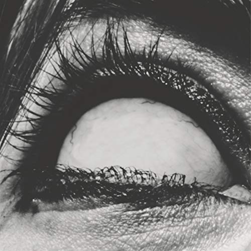 Close-up black and white image of an open eye with long lashes.