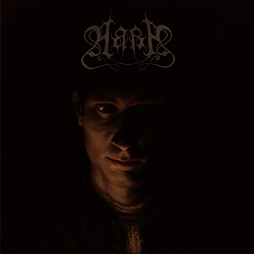 Dark album cover featuring a shadowed face and ornate band logo.