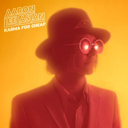 Aaron Lee Tasjan album cover with a man in a hat and red glasses.