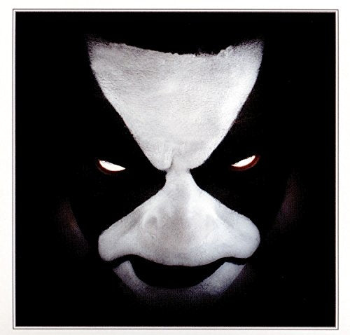 Close-up of a face with white and black corpse paint, red eyes.