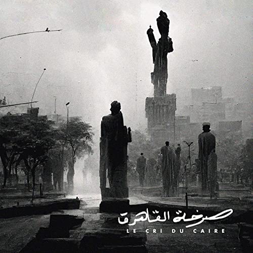 Black and white album cover featuring statues in a foggy Cairo cityscape.