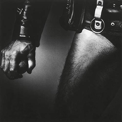 Black and white close-up of a person wearing leather gear holding a ball.