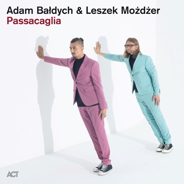 Two men in suits leaning against a white wall on the album cover.