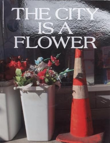 Book cover with title text over a flower arrangement and traffic cone.