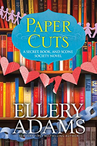 Book cover with title “Paper Cuts” and paper cut-out decorations.