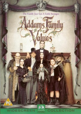 The Addams Family cast stands together in a graveyard against a large full moon.