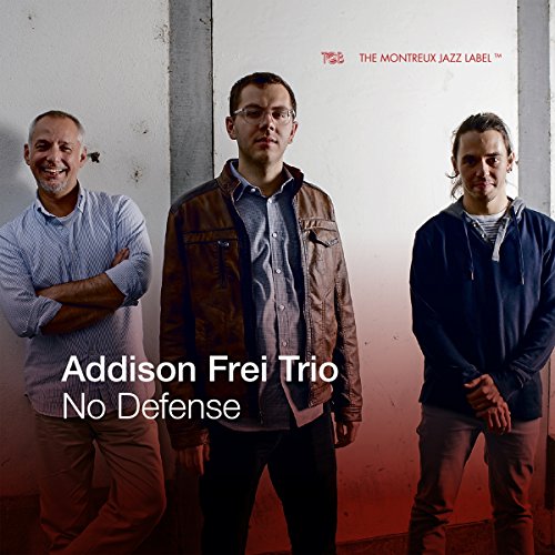 "Album cover featuring three men standing against a white wall with red gradient."