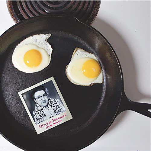Cast iron pan with fried eggs and a black and white portrait.
