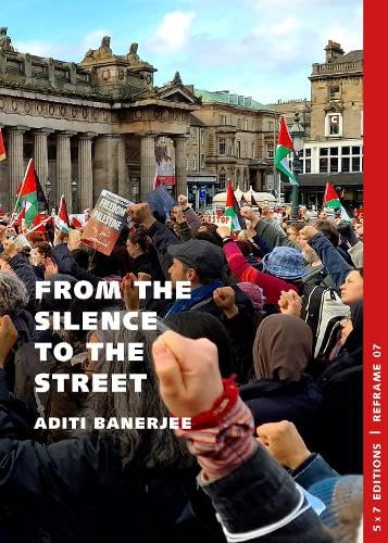 Protest crowd with Palestinian flags in front of a stone building.