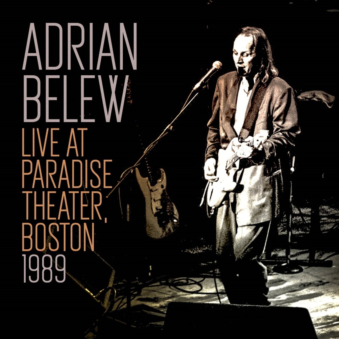 Adrian Belew album cover: musician with guitar on a dark stage.