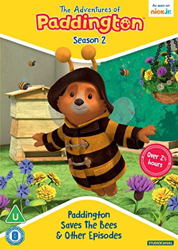 Paddington Bear dressed as a bee with antennae in a garden with beehives.
