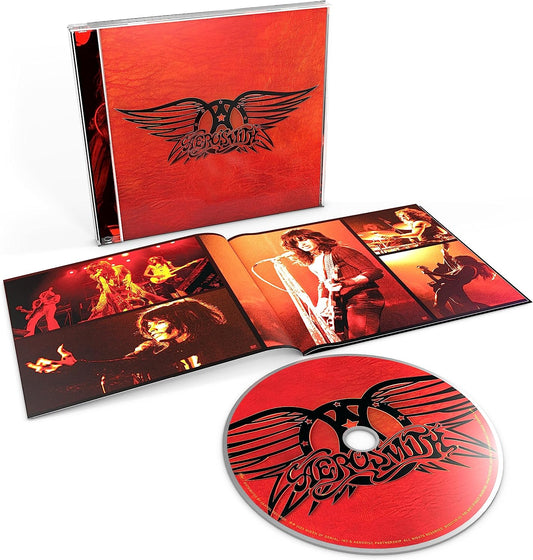 Aerosmith Greatest Hits CD case, open booklet with concert photos, and red branded disc.