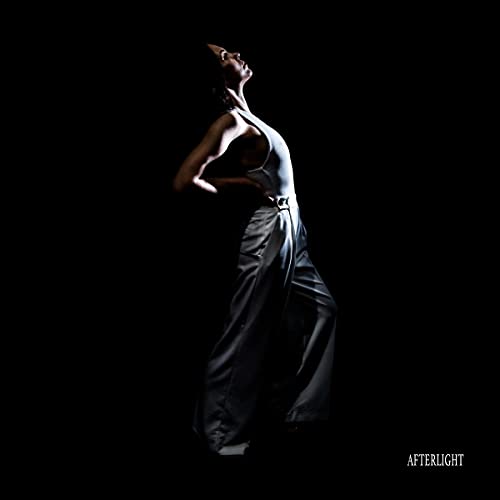 A person in light-colored clothing poses against a black background with the text Afterlight.