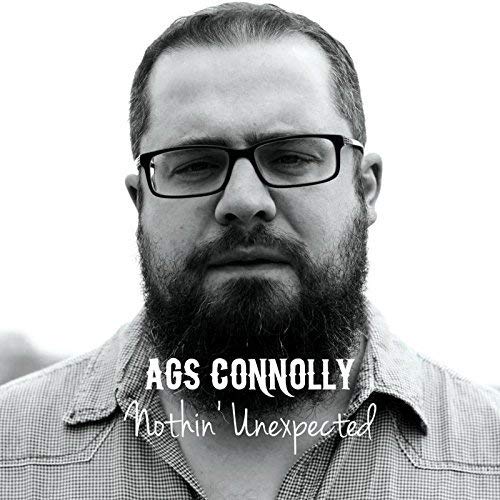 Black and white portrait of a bearded man with glasses, album cover.