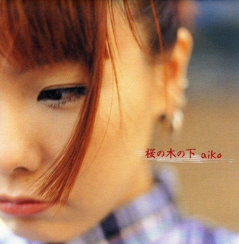 Close-up of a woman with auburn hair, featuring the text Sakura No Kinoshita aiko.