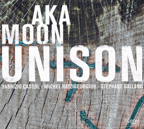 CD cover for "Aka Moon - Unison" with wood grain texture.