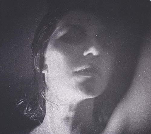 Black and white portrait of Aldous Harding, face partially obscured.