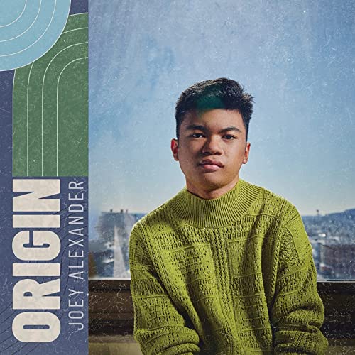 CD cover featuring Joey Alexander in a green sweater, city backdrop.