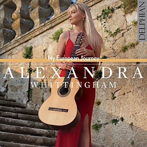 Woman in red dress holding guitar on stone steps with greenery.
