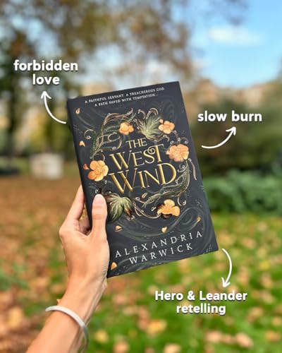Book cover with floral design, held in a hand outdoors.